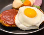 Hamburg Steak on black plate with egg fry.